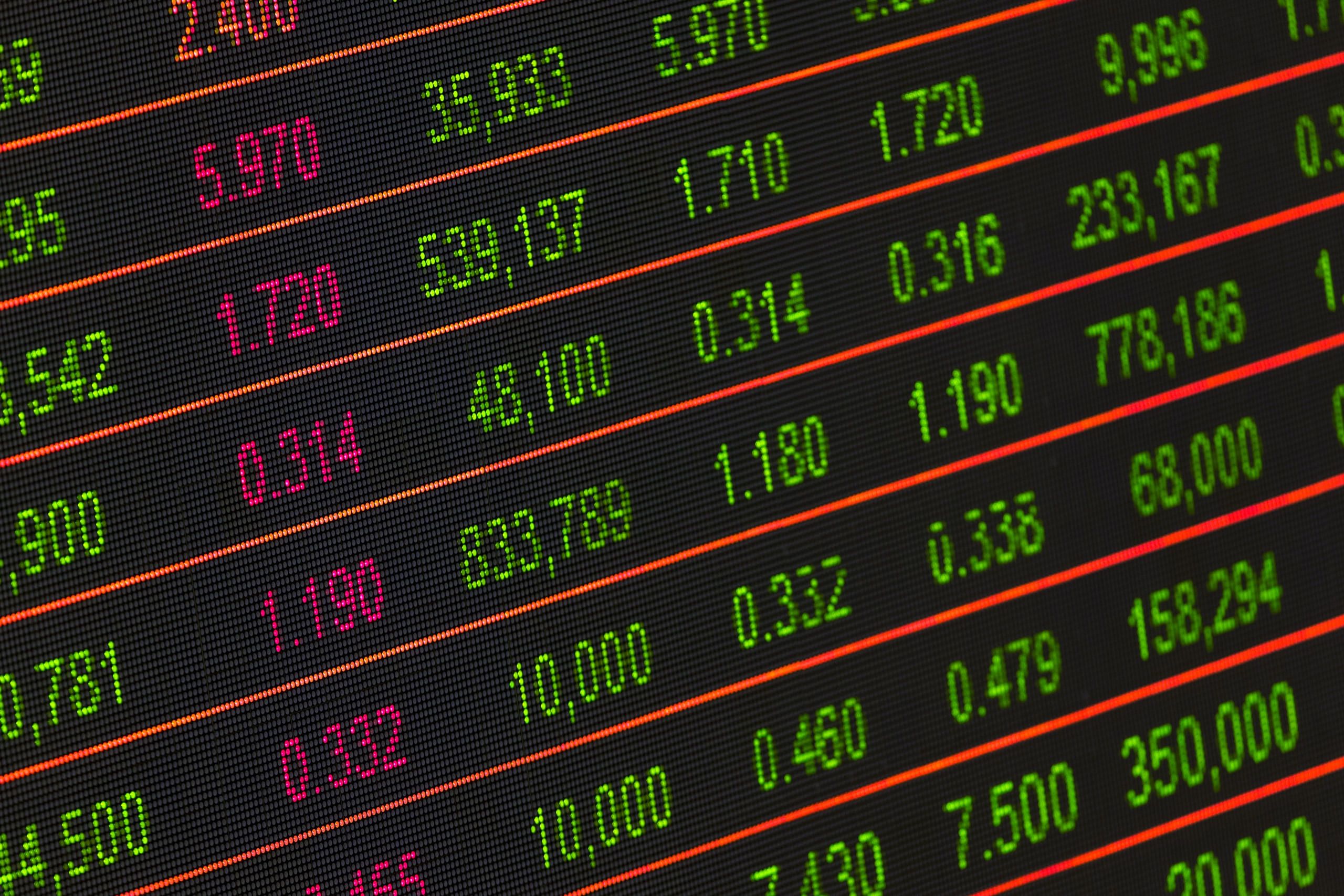 Rows of green and magenta prices beside six-figure volumes on an angled market quote board.
