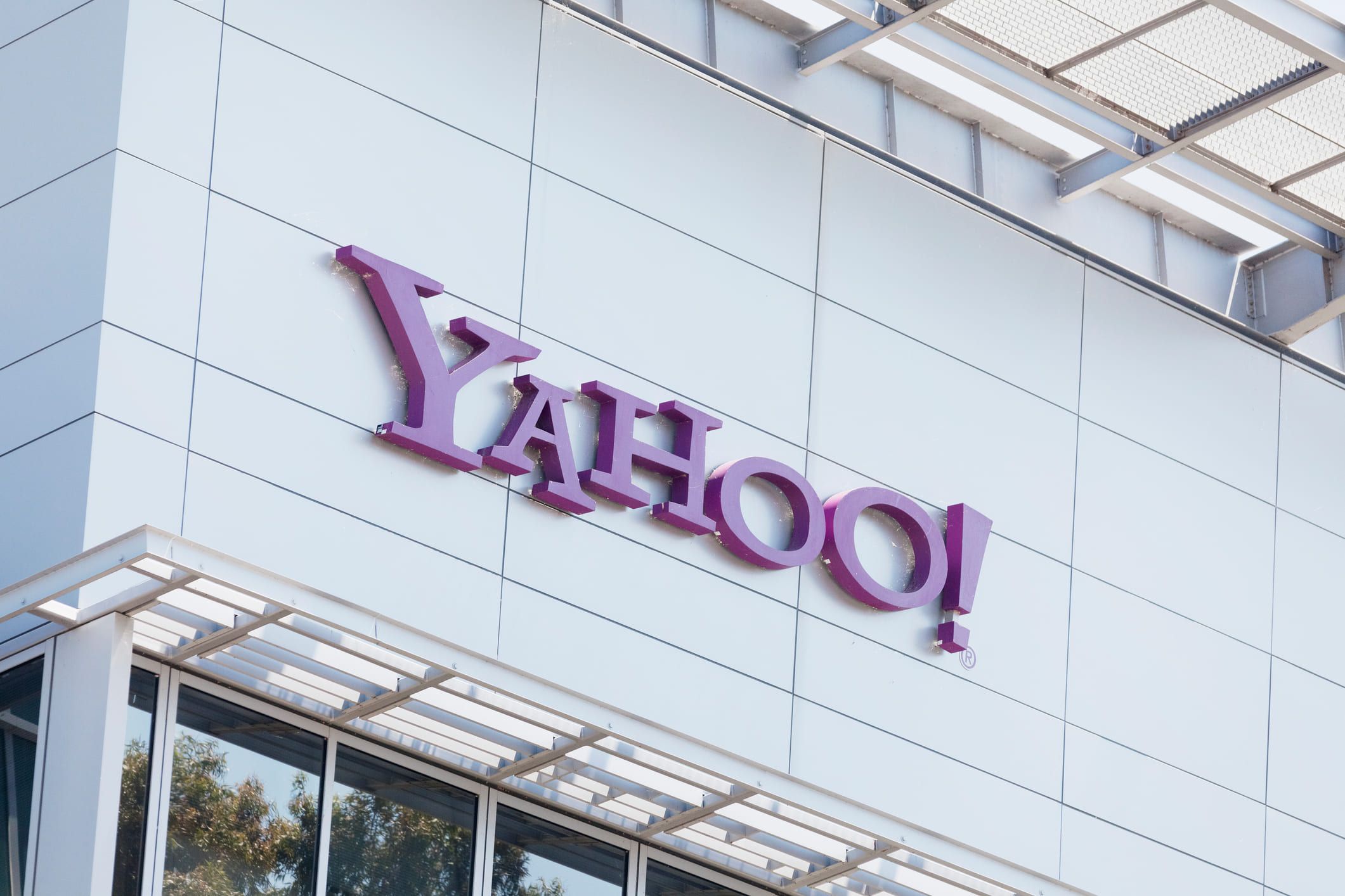 The purple Yahoo! logo in raised letters on the white panelled facade of an office building.